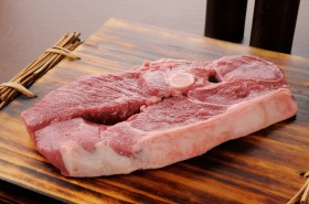Raw lamb shoulder chop on a cutting board