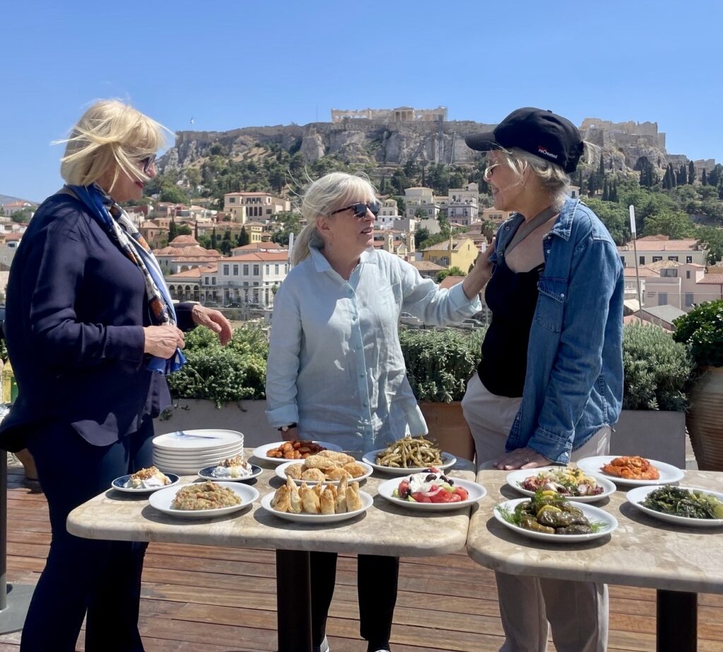 a group of women standing around a table with food on it