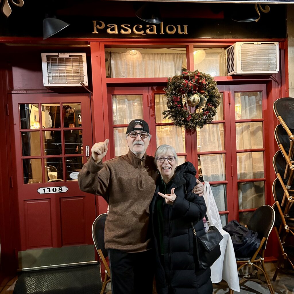 a man and woman posing for a picture in front of a red building