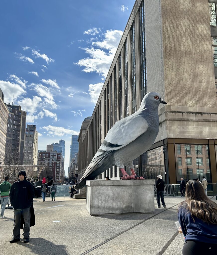 A statue of a pigeon in a city