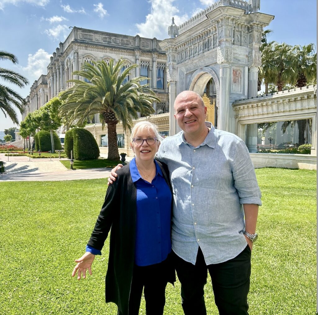A man and woman standing in front of a large building