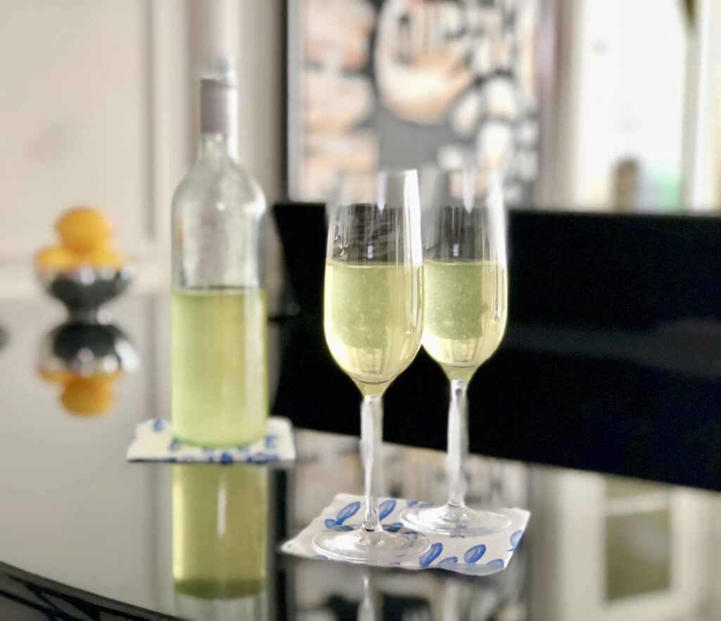 A bottle and glasses of wine on a table