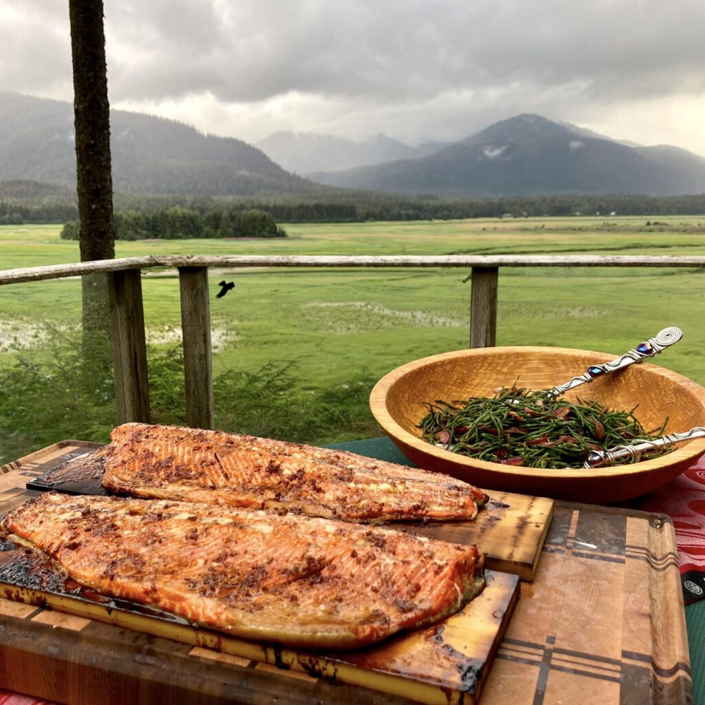 A table with food on it and a bowl of salad on it
