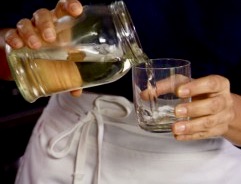 A person pouring water into a glass