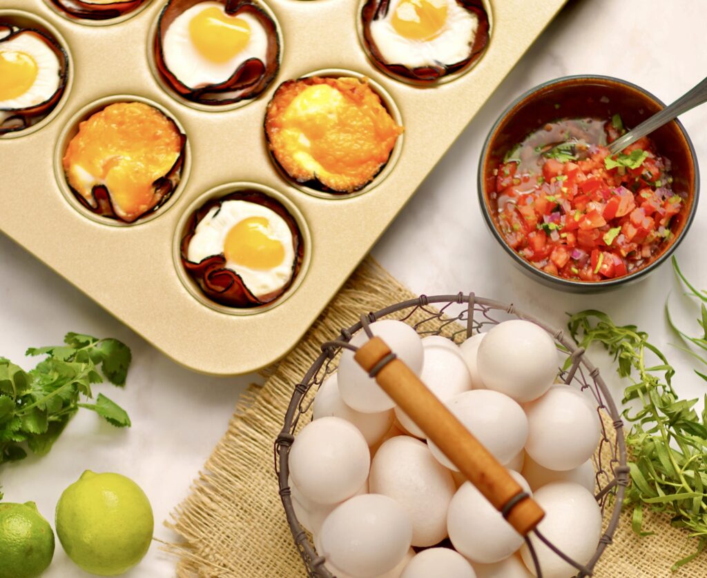 A muffin tin with eggs and salsa