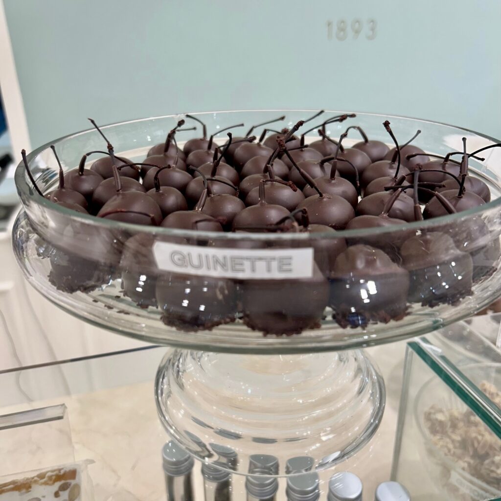 A glass bowl of chocolate cherries