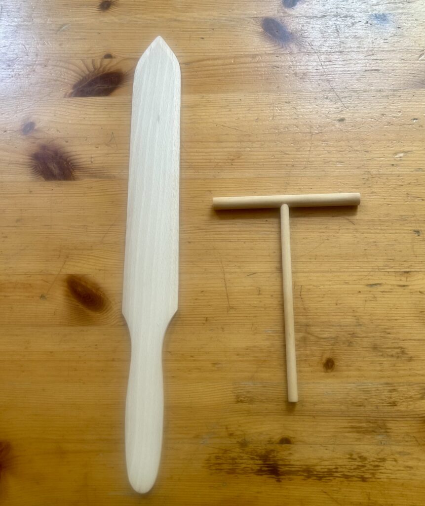 A wooden sword and t-bar on a table